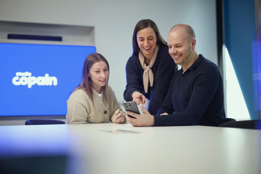 Teamleden van Studio Copain bekijken content op een smartphone